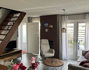 Gezellige woonkamer van TXL Huisje 299 in De Cocksdorp, Texel met comfortabele zithoek en toegang tot het terras.