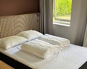 Sfeervolle slaapkamer in TXL Huisje 299, een vakantiehuis in De Cocksdorp, Texel. Gezellig interieur met uitzicht op groene natuur.