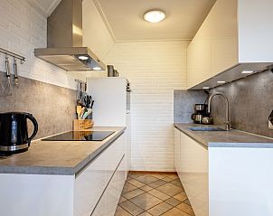 Stijlvolle keukeninrichting in Vakantiehuis Schelpenoord 129, De Cocksdorp, Texel, met moderne apparatuur en praktische indeling.