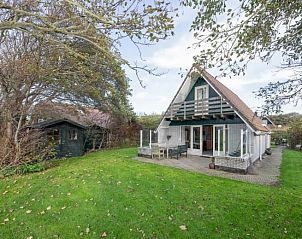 Vakantiehuis Schelpenoord 129 in De Cocksdorp, Texel, omgeven door weelderige natuur en ruime tuin, perfect voor een ontspannen vakantie.
