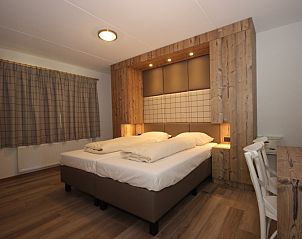 Stylish bedroom in Villa De Witte Hoek 138 conservatory, De Cocksdorp Texel, vacation home with wooden accents and cozy atmosphere.