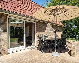 Terras van Bungalow De Witte Hoek 5 pers. 142 in De Cocksdorp Texel, met parasol en zitplaatsen op de Waddeneilanden.