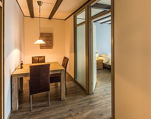 Eetruimte in Type X-7 vakantiehuis, De Cocksdorp, Texel met houten tafel en stoelen, Waddeneilanden.