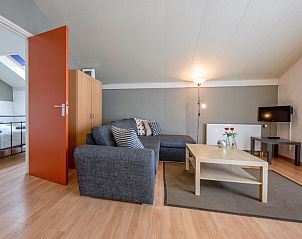 Gerumige Sitzecke im Ferienhaus Typ 9 - 2109, De Cocksdorp, Texel mit bequemem Sofa und Zugang zum Schlafzimmer.
