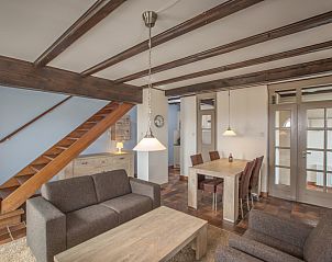 Eetkamer met houten tafel en comfortabele stoelen in Type T-3 vakantiehuis, De Cocksdorp.