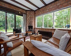 Gezellige woonkamer in Bungalow Tamarisk 138, Texel, met uitzicht op de groene tuin.