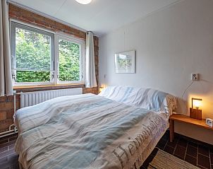 Slaapkamer in Bungalow Tamarisk 138, De Cocksdorp, met comfortabel tweepersoonsbed en groen uitzicht.