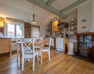 Dining area with wooden floor in vacation home Kikkertstraat 065, De Cocksdorp, Texel, ideal for cozy meals.