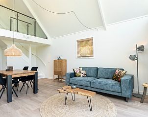 Eet- en woonruimte in Zeerus vakantiehuis, De Cocksdorp, Texel met houten tafel.