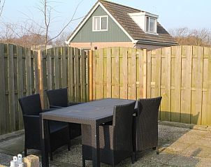 Gezellig terras bij Onder de vuurtoren 115, vakantiehuis in De Cocksdorp, Texel met houten schutting en tuinmeubilair.