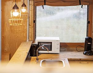 Terras met houten meubels bij Sluftervallei 6-persoons safaritent, De Cocksdorp, Texel, Waddeneilanden.