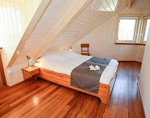 Gemtliches Schlafzimmer in Velduil Ferienhaus De Cocksdorp Texel mit Holzinterieur.
