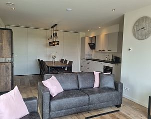 Experience comfort in the living room of Holiday Home De Slufter in De Cocksdorp, Texel, with modern furnishings and dining area.