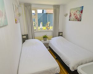 Cozy bedroom with two beds in vacation home Duinviooltje, De Cocksdorp, Texel.