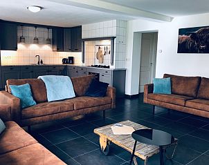 Gezellige woonkamer in Vakantiehuis De Muy, De Cocksdorp, Texel met comfortabele banken en moderne keuken.