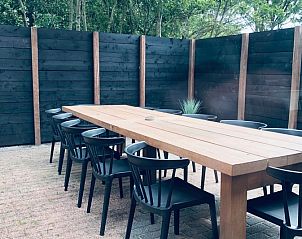 Buitenruimte met lange houten tafel in Vakantiehuis De Muy, De Cocksdorp, Texel voor al fresco dineren.