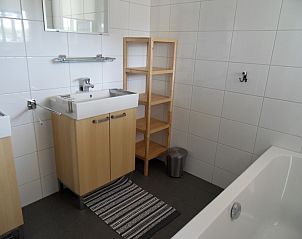 Modernes Badezimmer in Typ 7 - 2107 Ferienhaus De Cocksdorp Texel mit groem Waschbecken und Badewanne.