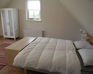 Helles Schlafzimmer in Typ 7 - 2107 Ferienhaus De Cocksdorp Texel mit groem Bett und Kleiderschrank.