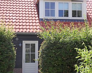 Vooraanzicht van vakantiehuis Type 8 - 2108 in De Cocksdorp, Texel, omgeven door groene natuur.