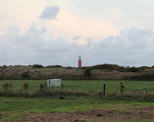 Uitzicht op vuurtoren vanaf Duin-/vuurtorenzicht vrijstaand vakantiehuis in De Cocksdorp, Texel omgeven door natuur.