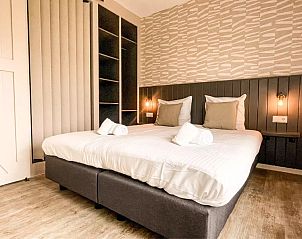 Ruime slaapkamer Vakantiehuis Hogezandskil in De Cocksdorp, Texel met tweepersoonsbed en warme accenten.