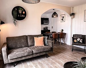 Gezellige woonkamer in Vakantiehuis De Roggesloot, De Cocksdorp, Texel met comfortabele bank en eethoek.