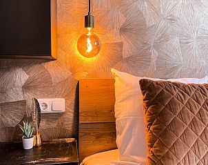 Knusse slaapkamer in Vakantiehuis De Roggesloot, De Cocksdorp, Texel met sfeervolle verlichting.