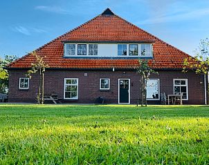 Buitenkant van Vakantiehuis De Roggesloot, De Cocksdorp, Texel met ruime tuin en rode dakpannen.