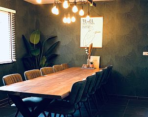 Speisesaal im Ferienhaus De Slufter, De Cocksdorp Texel mit groem Holztisch und stimmungsvoller Beleuchtung.