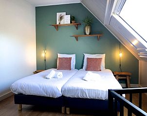 Gemtliches Schlafzimmer im Ferienhaus De Slufter, De Cocksdorp Texel mit zwei Einzelbetten und stimmungsvoller Beleuchtung.
