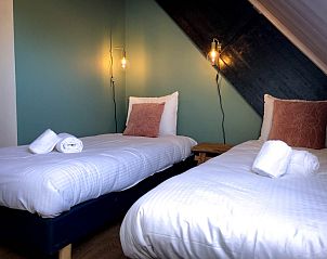 Gemtliches Schlafzimmer im Ferienhaus De Slufter, De Cocksdorp Texel mit Holzakzenten und warmer Beleuchtung.