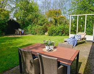 Ruim terras van Het Wulpenlied vakantiehuis in De Cocksdorp Texel met eettafel en ligstoel.