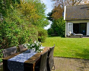 Buiten dineren bij Het Wulpenlied vakantiehuis in De Cocksdorp Texel met groene omgeving.
