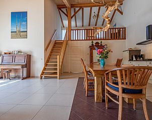 Open leefruimte met houten trap in Vakantiehuis Paal 86, De Cocksdorp, Texel.