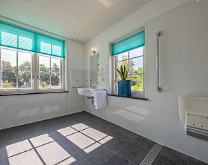 Lichte badkamer met grote ramen in Vakantiehuis Paal 86, De Cocksdorp, Texel.