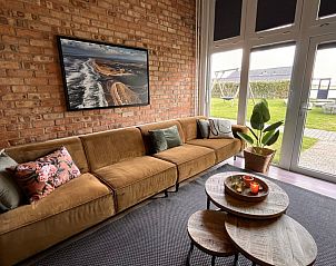 Uitzicht vanuit de woonkamer van Noorderwind vakantiehuis, De Cocksdorp, Texel met grote ramen en tuin.