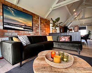 Sfeervolle woonkamer van Noorderwind, De Cocksdorp, Texel met moderne bank en decoratieve kaarsen.