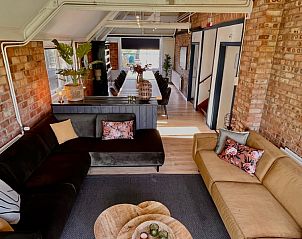 Comfortabele zithoek in Noorderwind accommodatie, De Cocksdorp, Texel met kleurrijke kussens en planten.