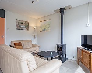 Comfortabele woonkamer van Vakantiehuis Slufterhoek 118 in Texel met houtkachel en moderne inrichting.