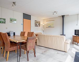 Ruime eetkamer in Vakantiehuis Slufterhoek 118, Texel, met houten tafel en comfortabele stoelen.