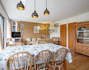 Esszimmer des Ferienhauses Slufterhoek 072 in De Cocksdorp, Texel mit groem Esstisch und stimmungsvoller Beleuchtung.