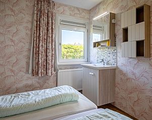 Zweites Schlafzimmer im Ferienhaus Slufterhoek 072 in De Cocksdorp, Texel mit Blick auf den Garten.