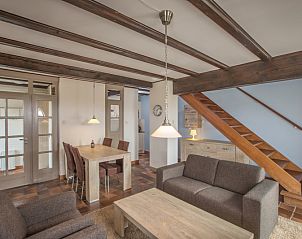 Eetkamer en zithoek in Type T-4 vakantiehuis, De Cocksdorp, Texel, met rustieke inrichting.