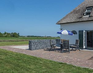Terras met parasol bij Type T-4 vakantiehuis, De Cocksdorp, Texel, met uitzicht op het landschap.