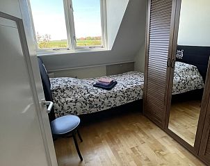 Knusse slaapkamer met uitzicht in Vakantiehuisje in De Cocksdorp, Texel.