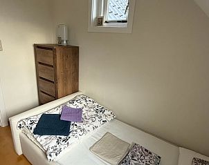 Slaapkamer met houten meubels in Vakantiehuisje in De Cocksdorp, Texel.