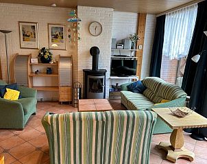Gezellige woonkamer van Vakantiehuis Slufterhoek 128 in De Cocksdorp, Texel met open haard.