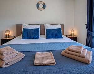 Knusse slaapkamer in Appartement A in De Cocksdorp Texel met opgemaakte bedden.