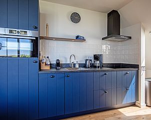 Moderne keuken in Appartement C, De Cocksdorp, Texel met blauwe kasten en hoogwaardige apparatuur.