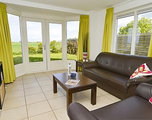 Lichte woonkamer in Plexat, vakantiehuis in De Cocksdorp, Texel met uitzicht op de tuin.